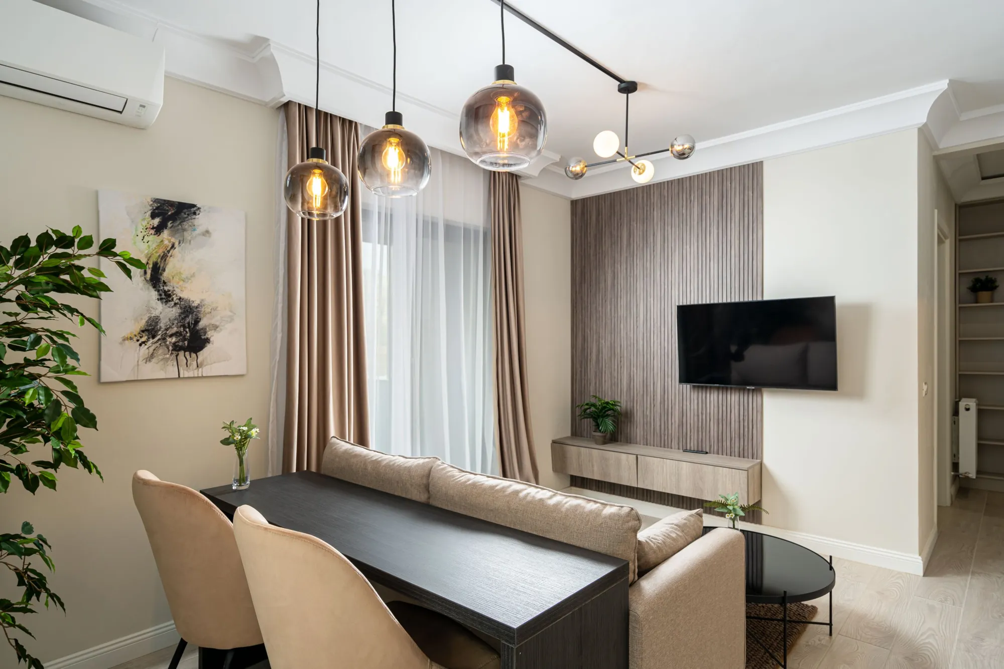 Living cu masă, canapea și perete decorativ într-un apartament din Casa Presei