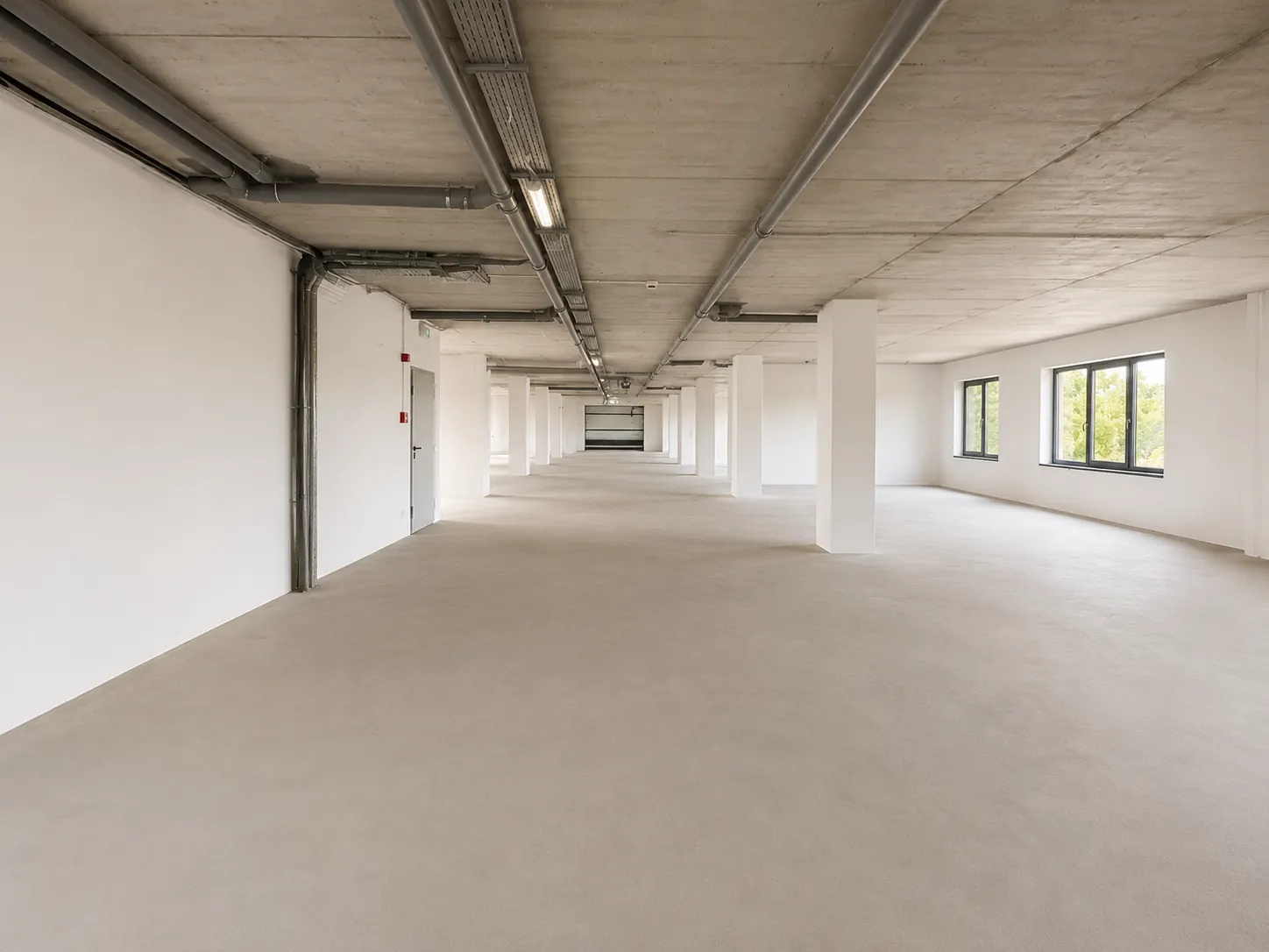 Interiorul spațiului comercial de 720 mp: open-space finisat, cu stâlpi și ferestre
